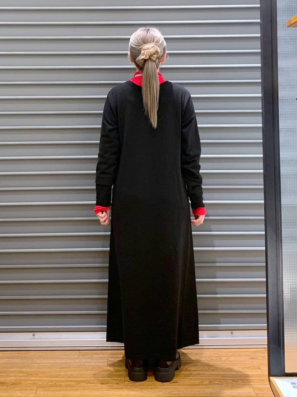 ブラック系のショルダーバッグ、ブラック系のブーツ、ブラック系のワンピースを着用したレディースの冬コーディネートの2枚目の写真