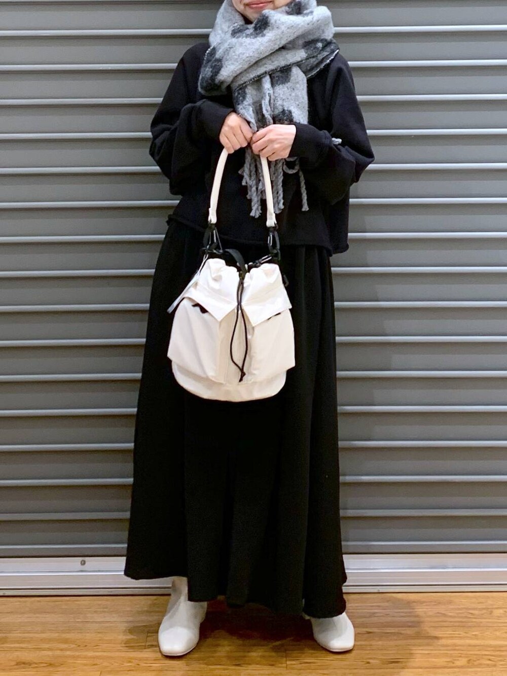 ホワイト系のショルダーバッグ、ホワイト系のブーツ、ブラック系のその他パンツを着用したレディースの秋コーディネートの5枚目の写真