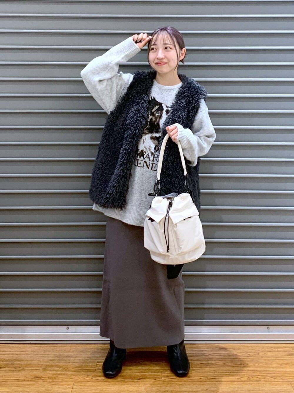 ホワイト系のショルダーバッグ、グレー系のスカート、ブラック系のブーツを着用したレディースの冬コーディネートの5枚目の写真