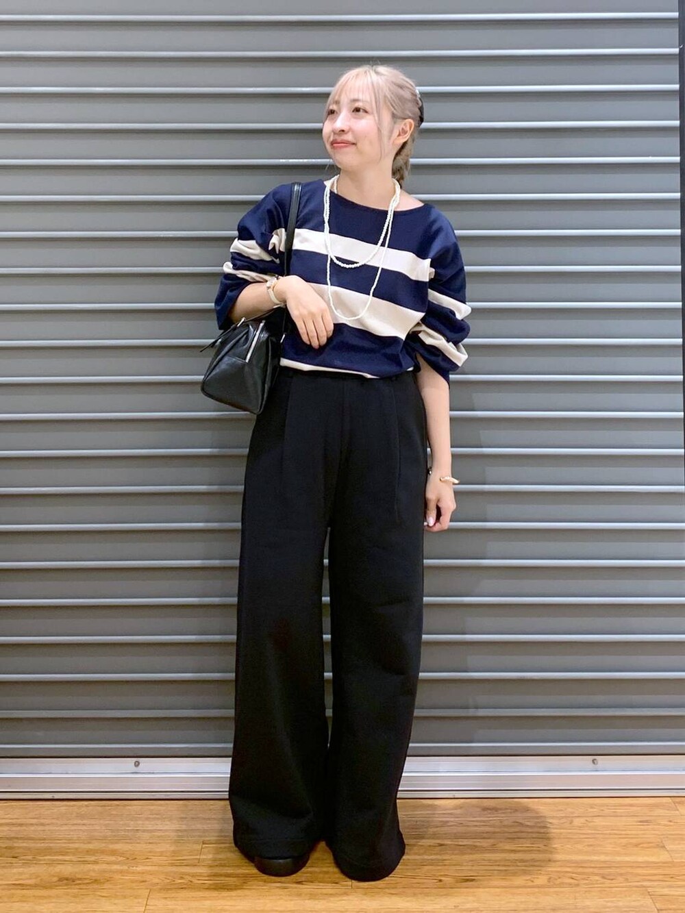 ブラック系のスウェットパンツ、ブラック系のサンダル、ブルー系のTシャツ/カットソーを着用したレディースの秋コーディネートの4枚目の写真