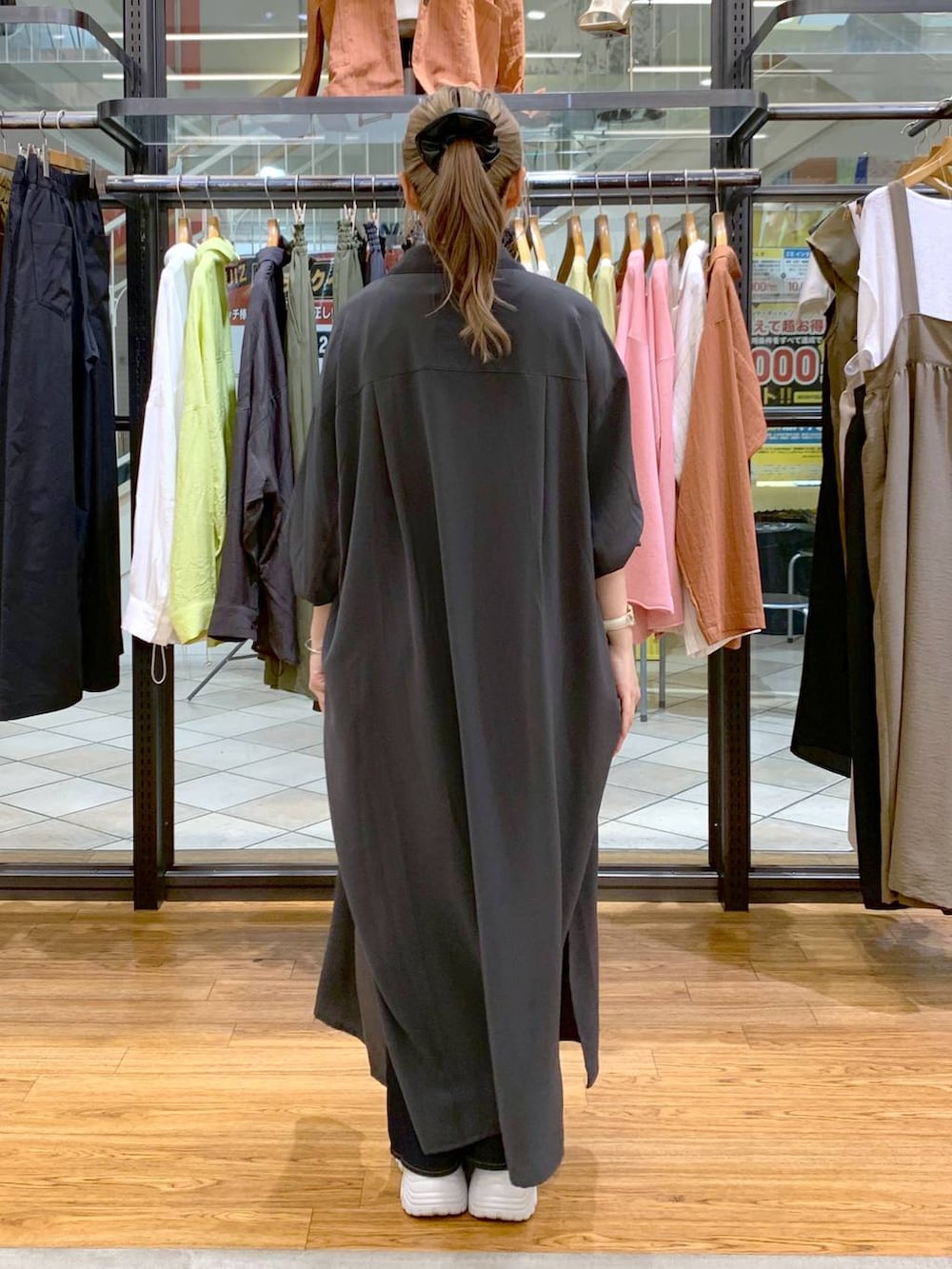 グレー系のワンピース、ホワイト系のタンクトップ、ブルー系のデニムパンツを着用したレディースの春コーディネートの2枚目の写真