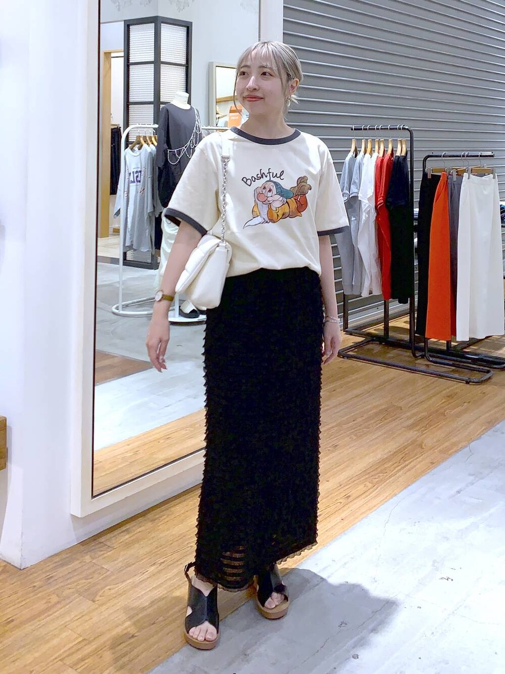 ホワイト系のショルダーバッグ、ブラック系のスカート、ブラック系のサンダルを着用したレディースの夏コーディネートの4枚目の写真