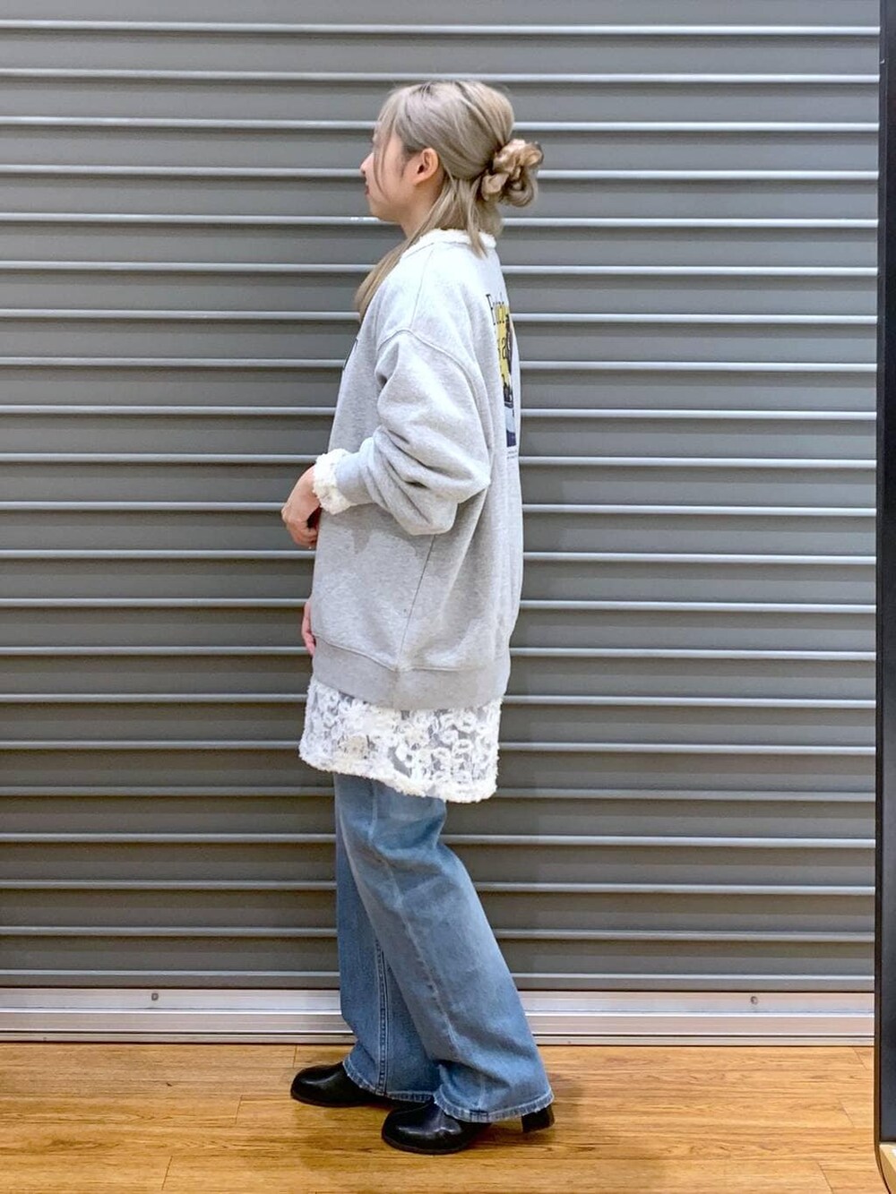 ブラック系のショルダーバッグ、ブルー系のデニムパンツ、ブラック系のブーツを着用したレディースの冬コーディネートの3枚目の写真