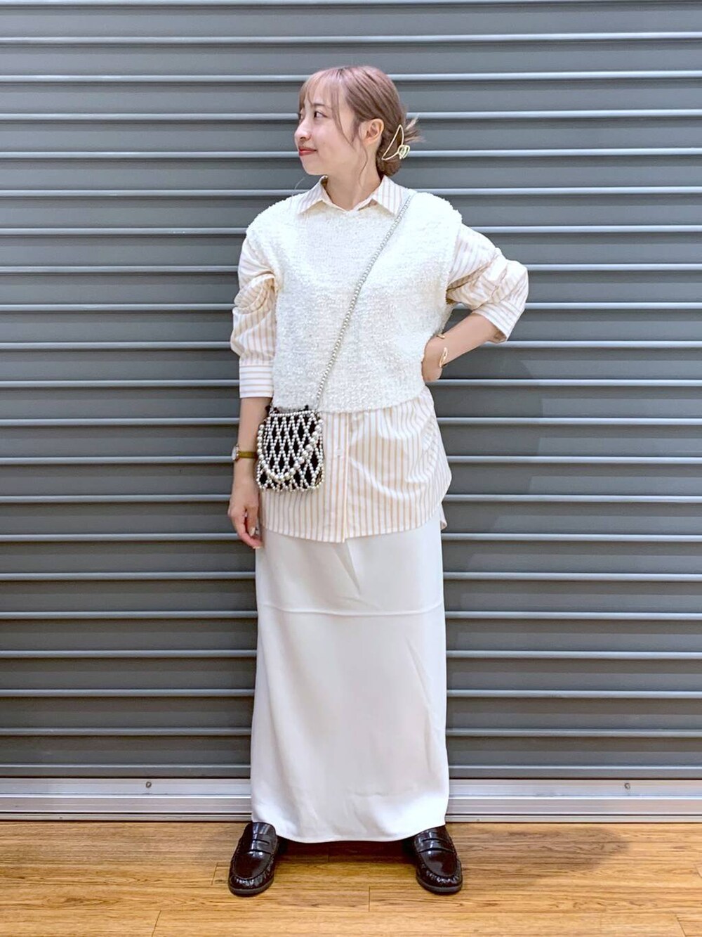 シルバー系のショルダーバッグ、ホワイト系のスカート、オレンジ系のシャツ/ブラウスを着用したレディースの秋コーディネートの7枚目の写真