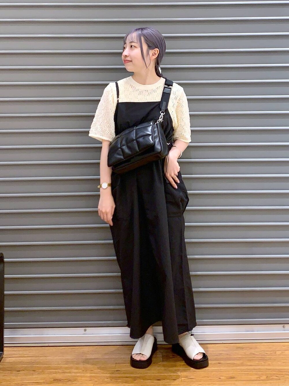 ブラック系のショルダーバッグ、ブラック系のワンピース、ホワイト系のサンダルを着用したレディースの春コーディネートの4枚目の写真