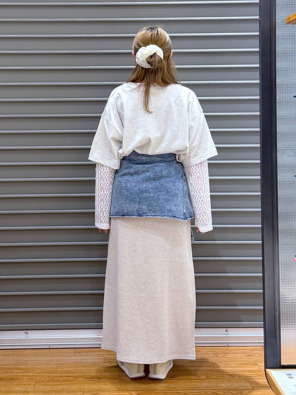 ベージュ系のスカート、ホワイト系のスニーカー、グレー系のショルダーバッグを着用したレディースの春コーディネートの2枚目の写真