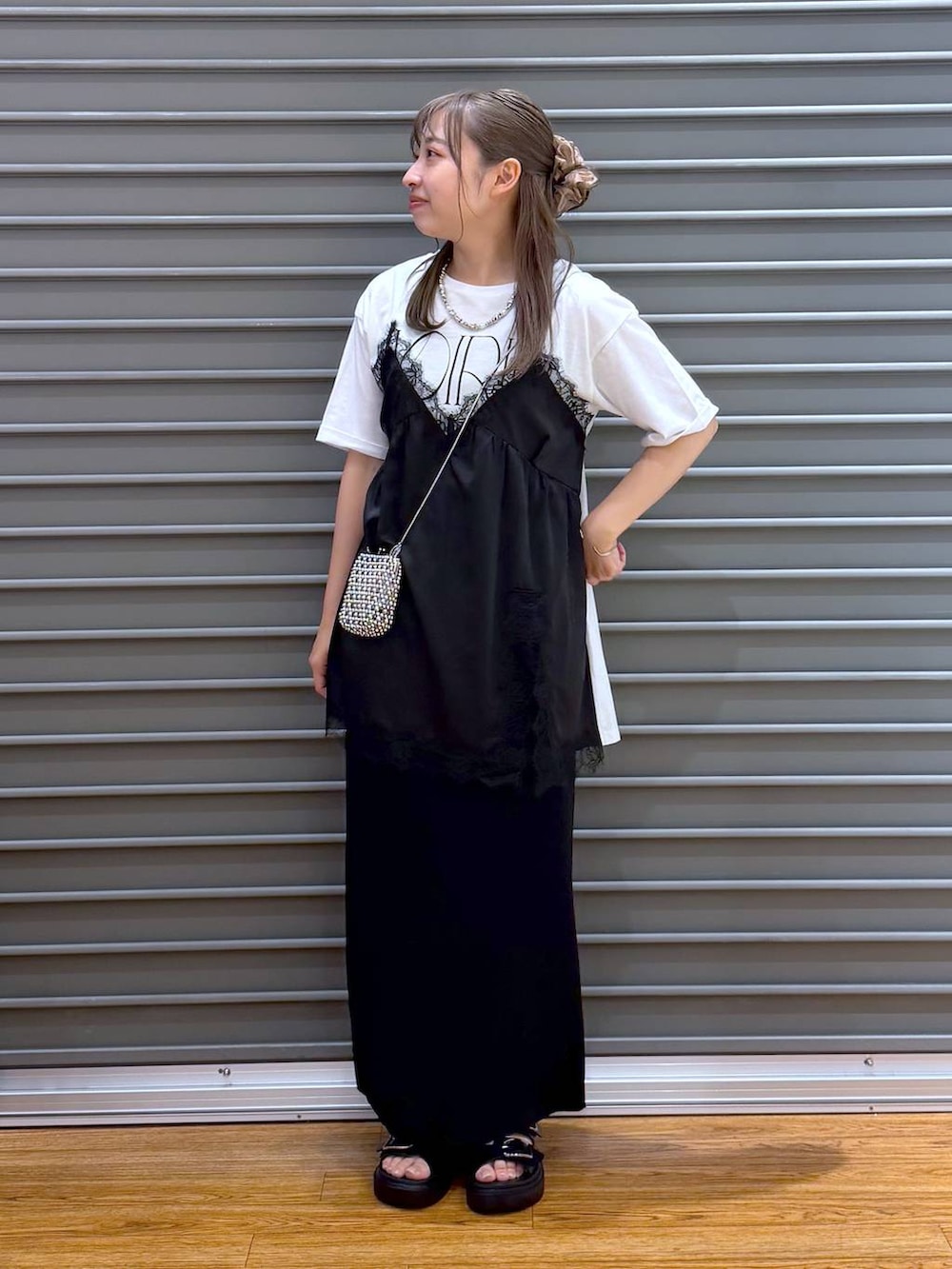 ブラック系のスカート、ブラック系のサンダル、ホワイト系のTシャツ/カットソーを着用したレディースの夏コーディネートの5枚目の写真
