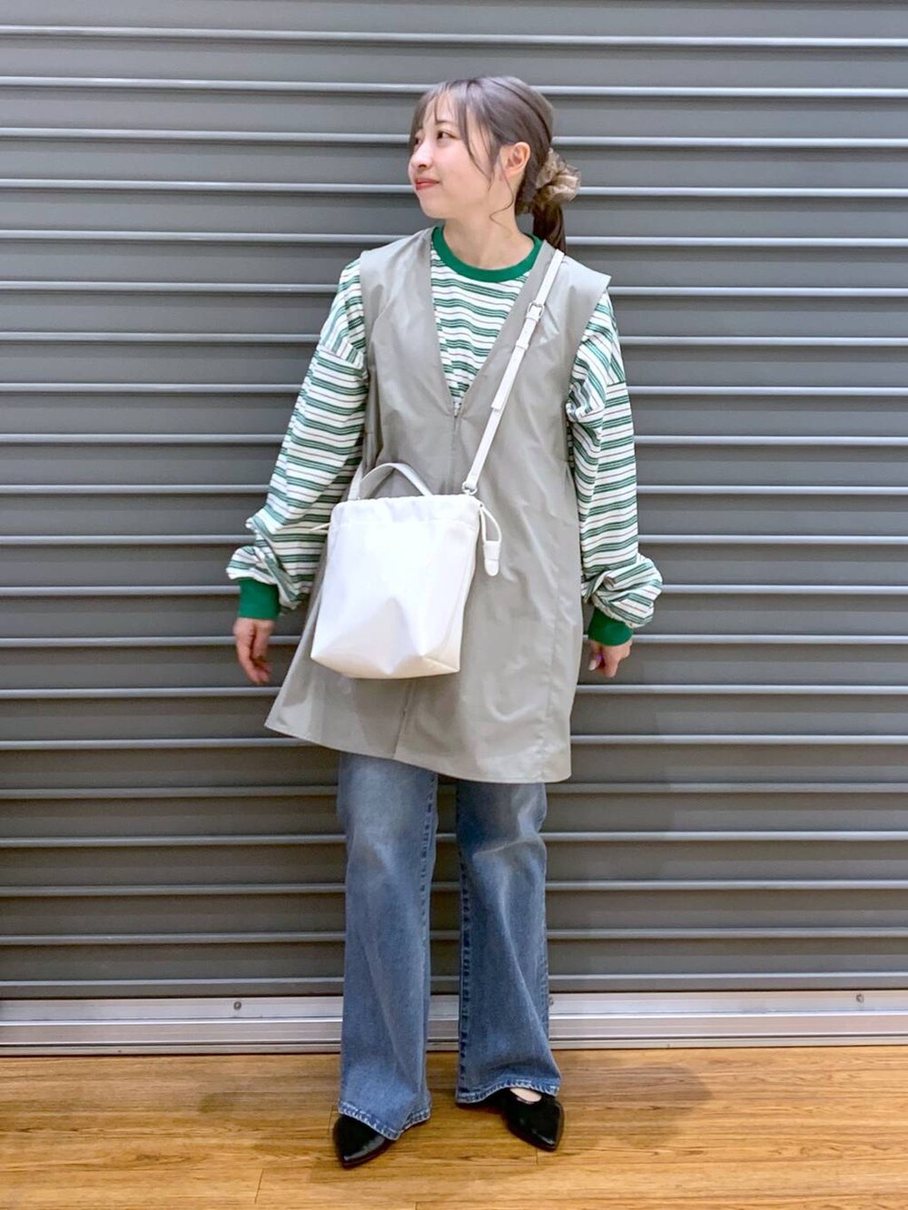 グリーン系のワンピース、ブルー系のデニムパンツ、ブラック系のパンプスを着用したレディースの春コーディネートの5枚目の写真