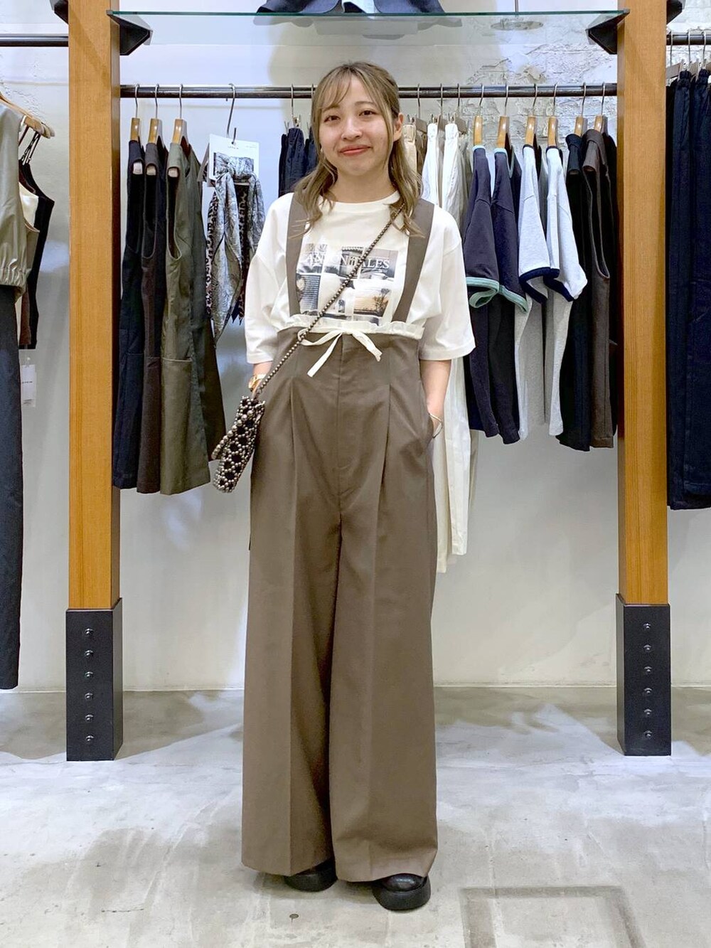 ブラック系のショルダーバッグ、ブラウン系のその他パンツ、ブラック系のサンダルを着用したレディースの秋コーディネートの7枚目の写真