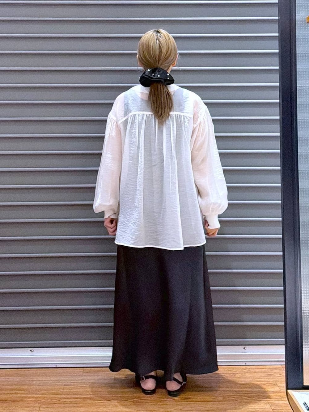 ベージュ系のシャツ/ブラウス、ブラック系のスカート、ブラック系のパンプスを着用したレディースの春コーディネートの2枚目の写真