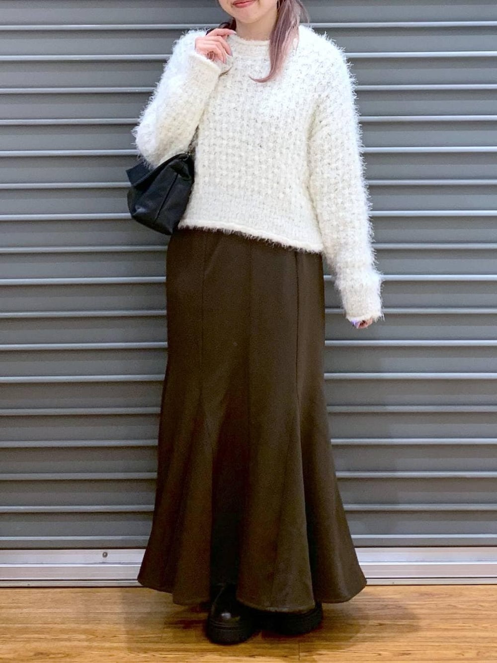 ブラウン系のブーツ、ホワイト系のニット/セーター、ブラック系のショルダーバッグを着用したレディースの冬コーディネートの5枚目の写真