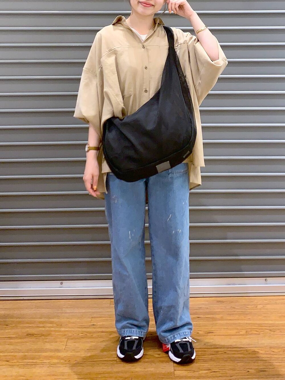ブラック系のスニーカー、ブラック系のショルダーバッグ、ベージュ系のシャツ/ブラウスを着用したレディースの春コーディネートの3枚目の写真