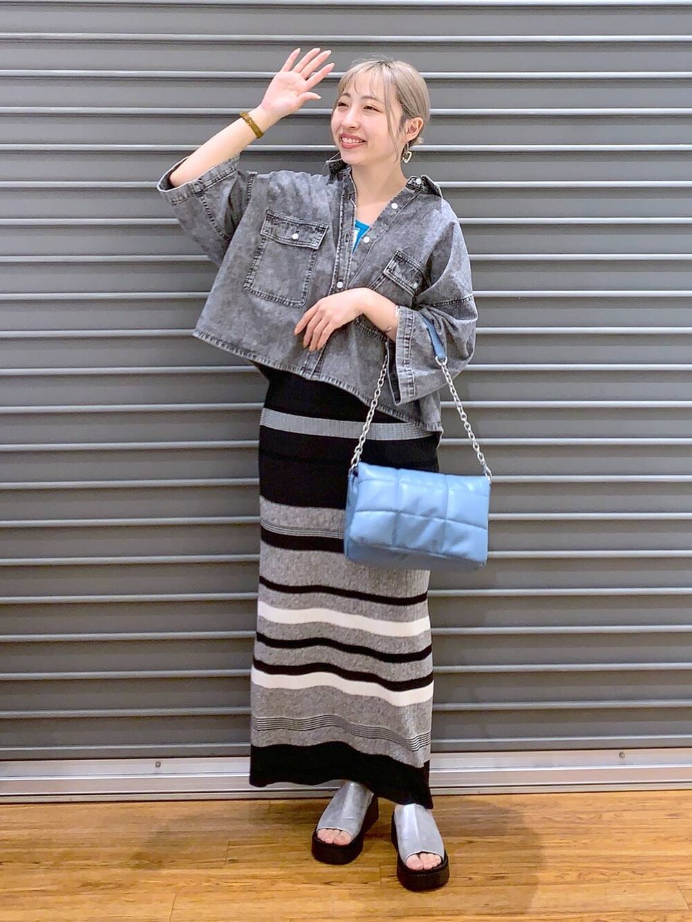ブルー系のショルダーバッグ、ブラック系のシャツ/ブラウス、グレー系のサンダルを着用したレディースの春コーディネートの6枚目の写真