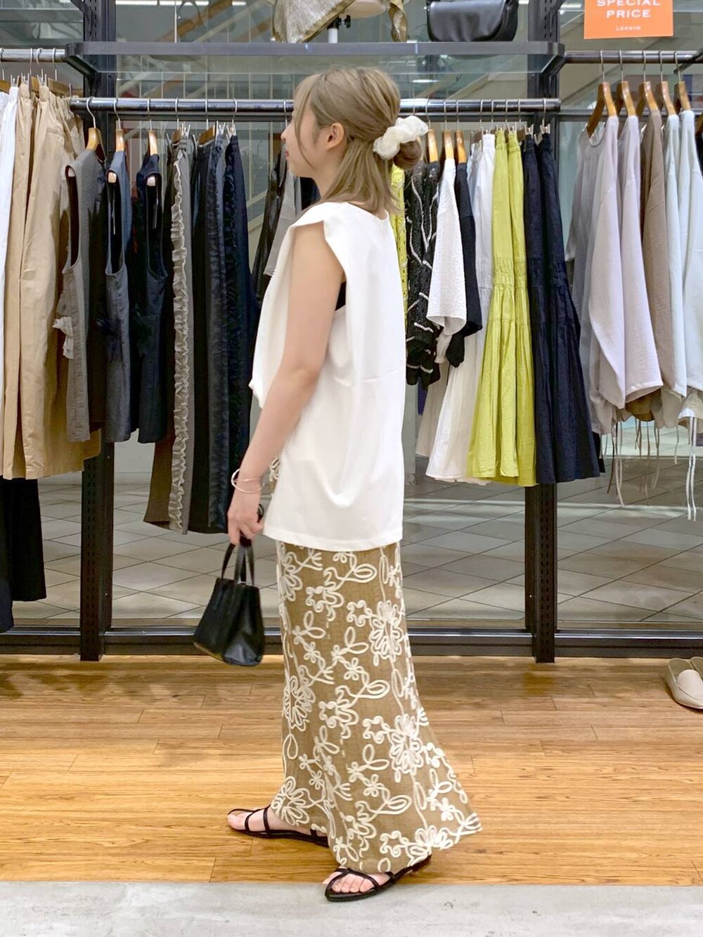 ホワイト系のTシャツ/カットソー、ブラック系のサンダル、ブラック系のショルダーバッグを着用したレディースの夏コーディネートの3枚目の写真