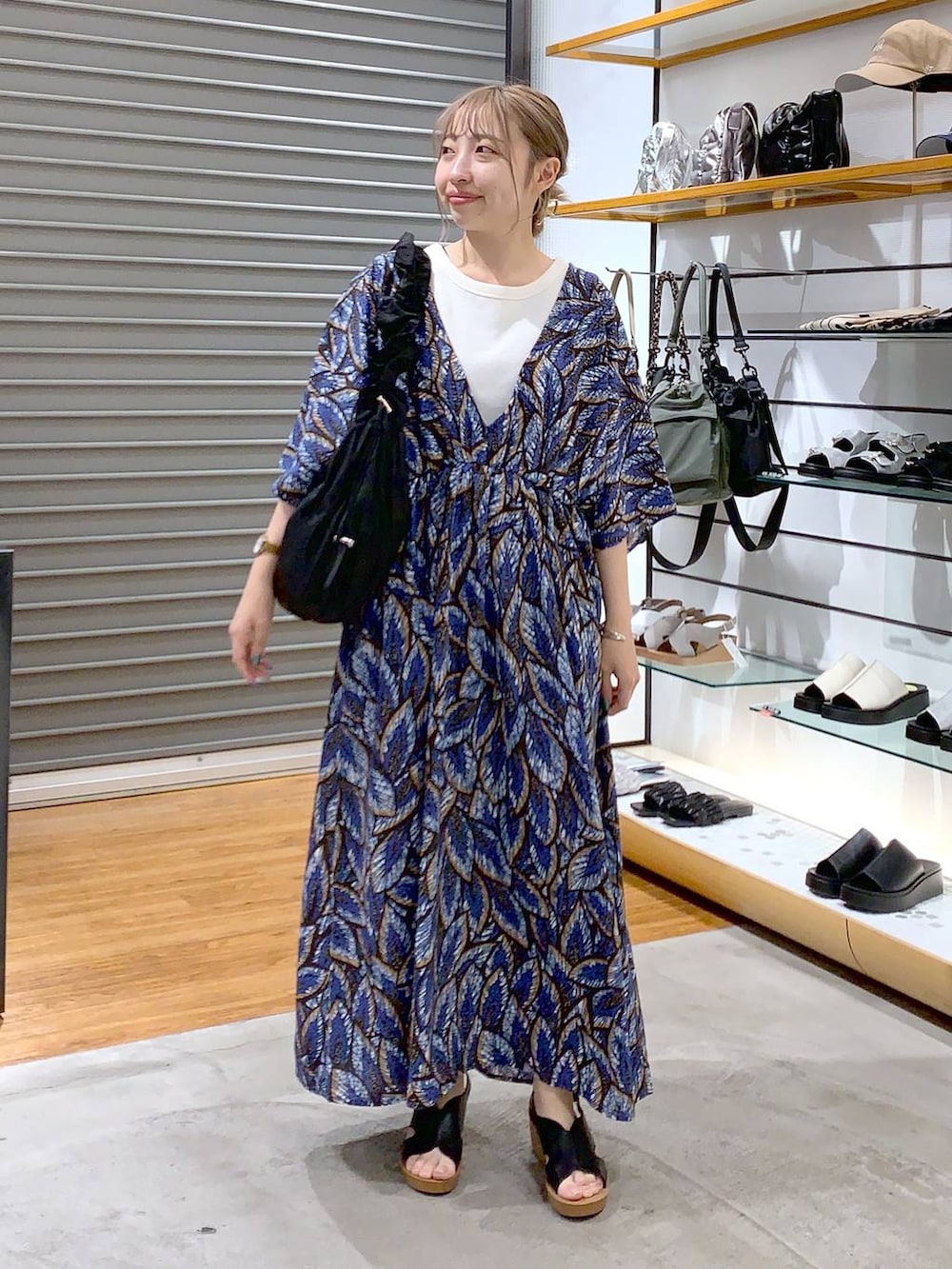 ブラック系のショルダーバッグ、ブラック系のサンダル、ホワイト系のタンクトップを着用したレディースの夏コーディネートの4枚目の写真