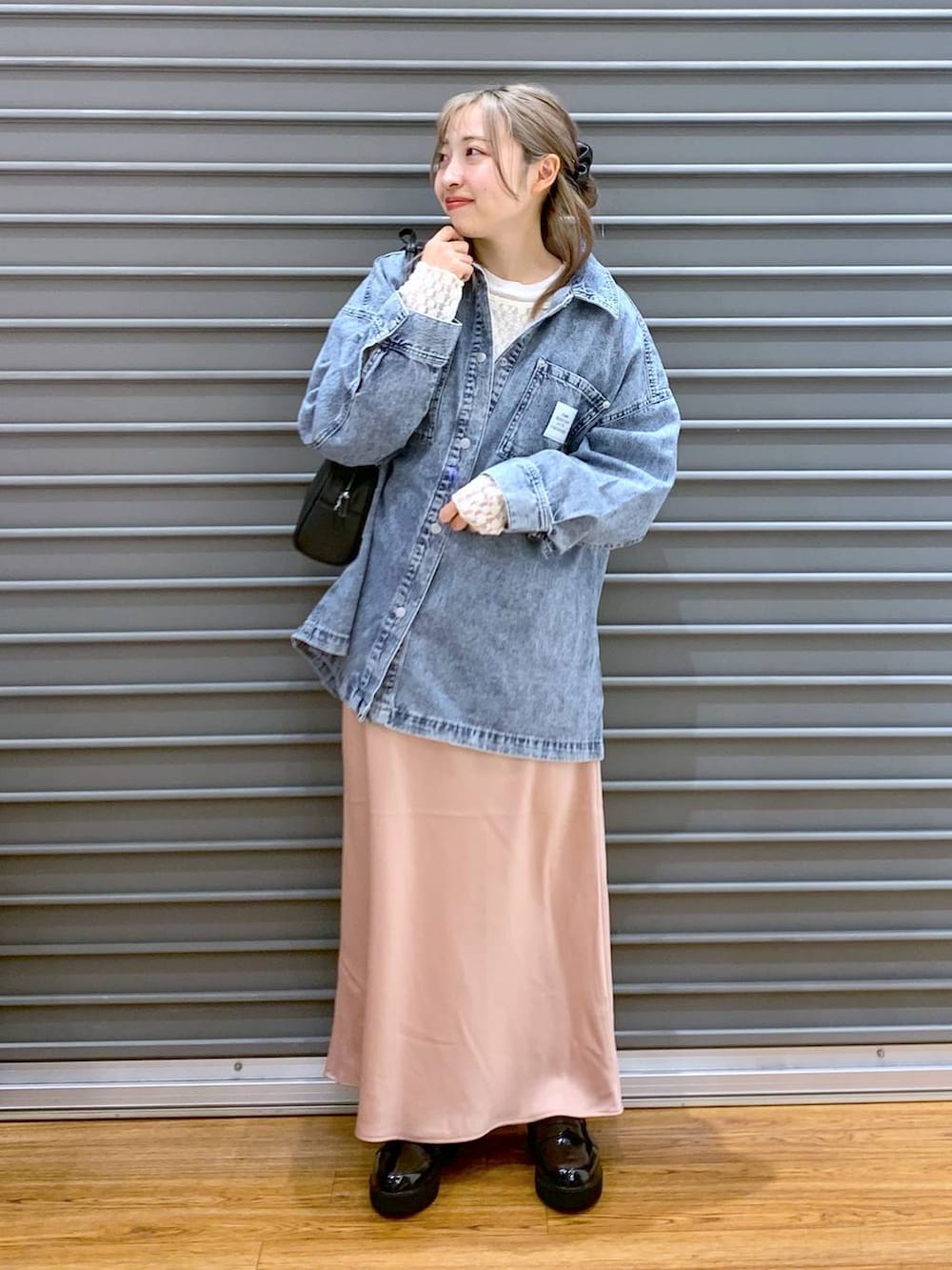 ピンク系のスカート、ブルー系のシャツ/ブラウス、ブラック系のショルダーバッグを着用したレディースの春コーディネートの3枚目の写真