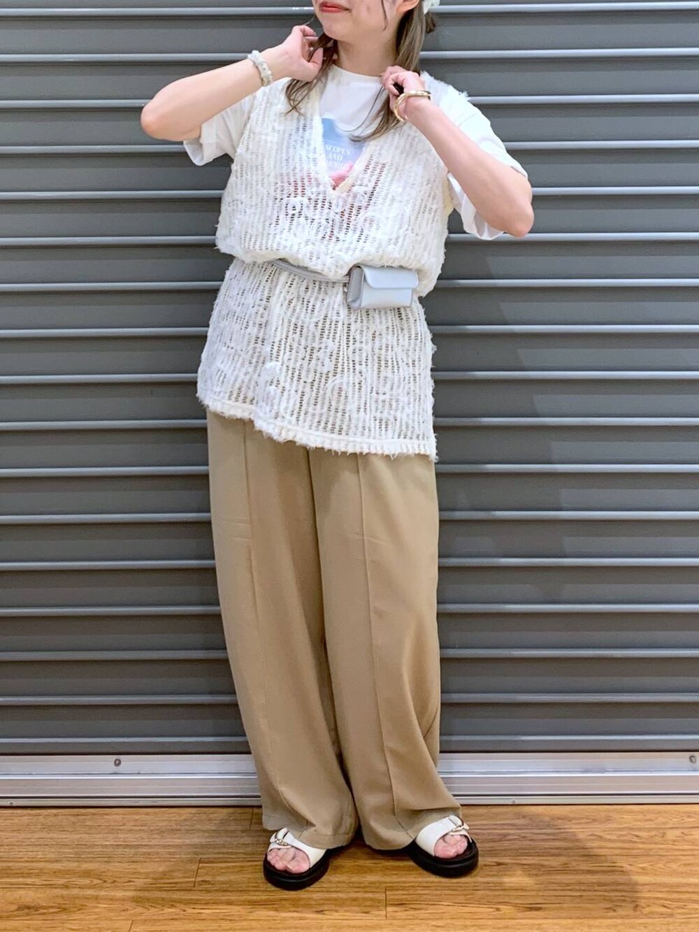 ベージュ系のその他パンツ、ホワイト系のベスト、ホワイト系のサンダルを着用したレディースの春コーディネートの4枚目の写真