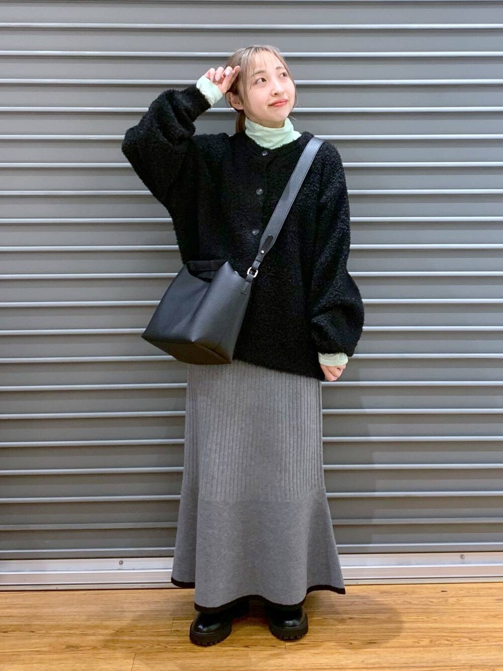 ブラック系のブーツ、ブラック系のワンピース、グリーン系のTシャツ/カットソーを着用したレディースの冬コーディネートの8枚目の写真