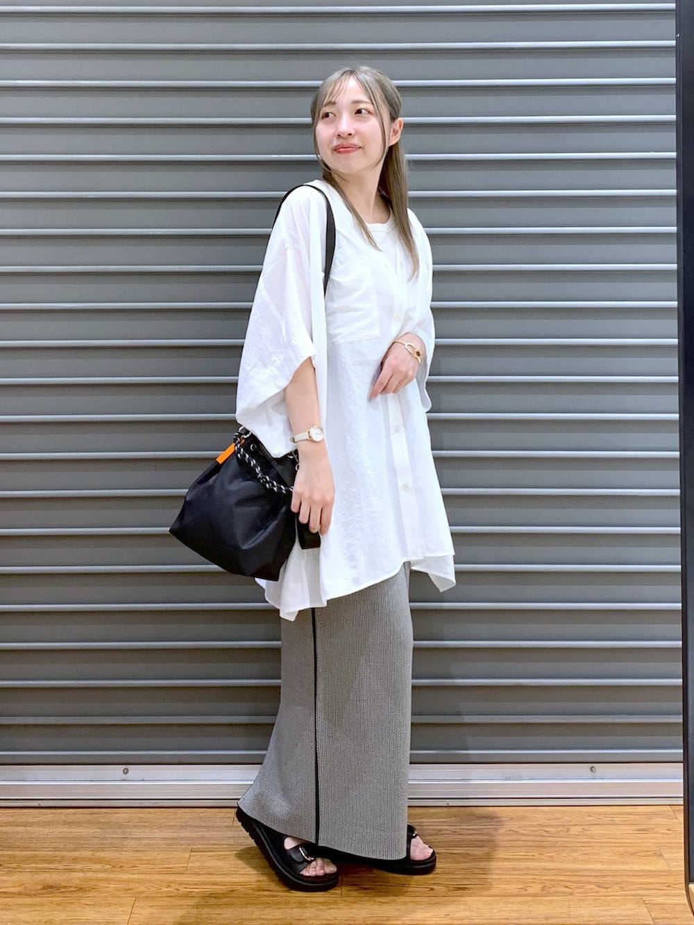 ホワイト系のTシャツ/カットソー、ブラック系のスカート、ブラック系のサンダルを着用したレディースの夏コーディネートの5枚目の写真