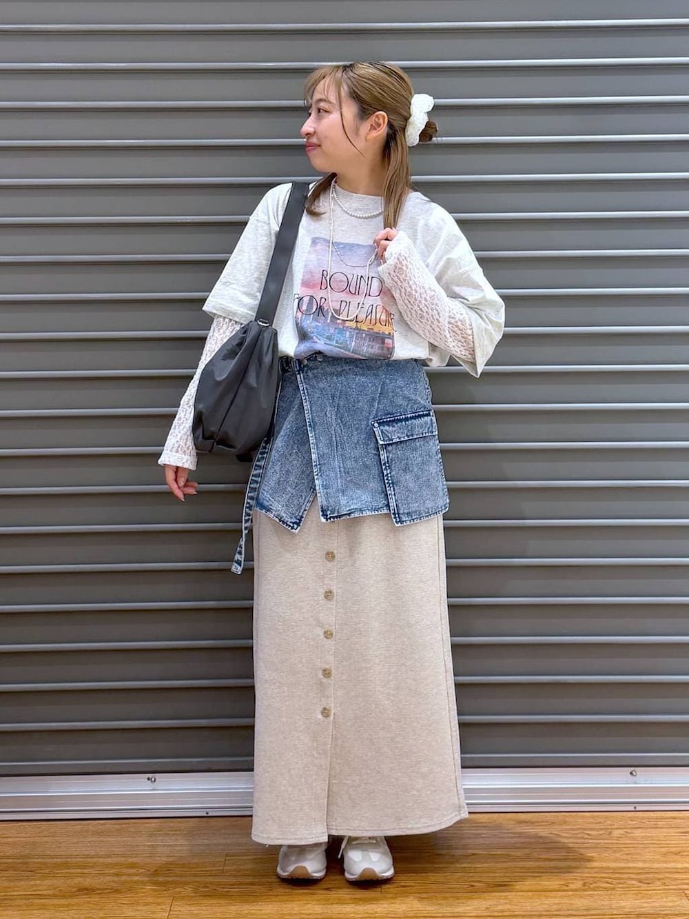 ベージュ系のスカート、ホワイト系のスニーカー、グレー系のショルダーバッグを着用したレディースの春コーディネートの6枚目の写真