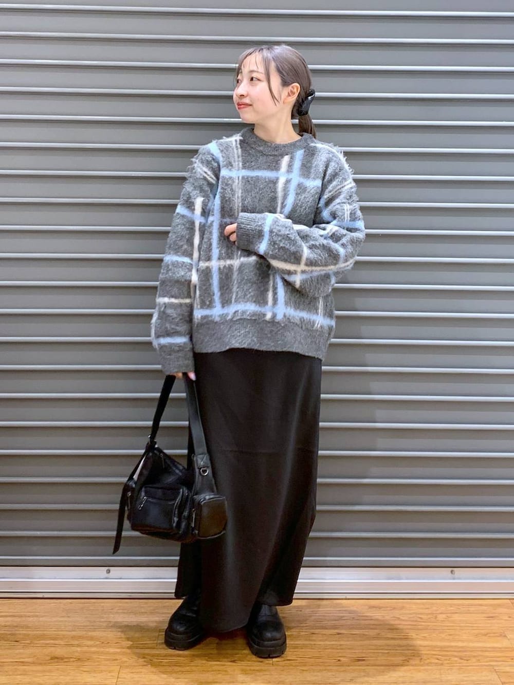 ブラック系のスカート、ブラック系のブーツ、ブラック系のショルダーバッグを着用したレディースの冬コーディネートの4枚目の写真