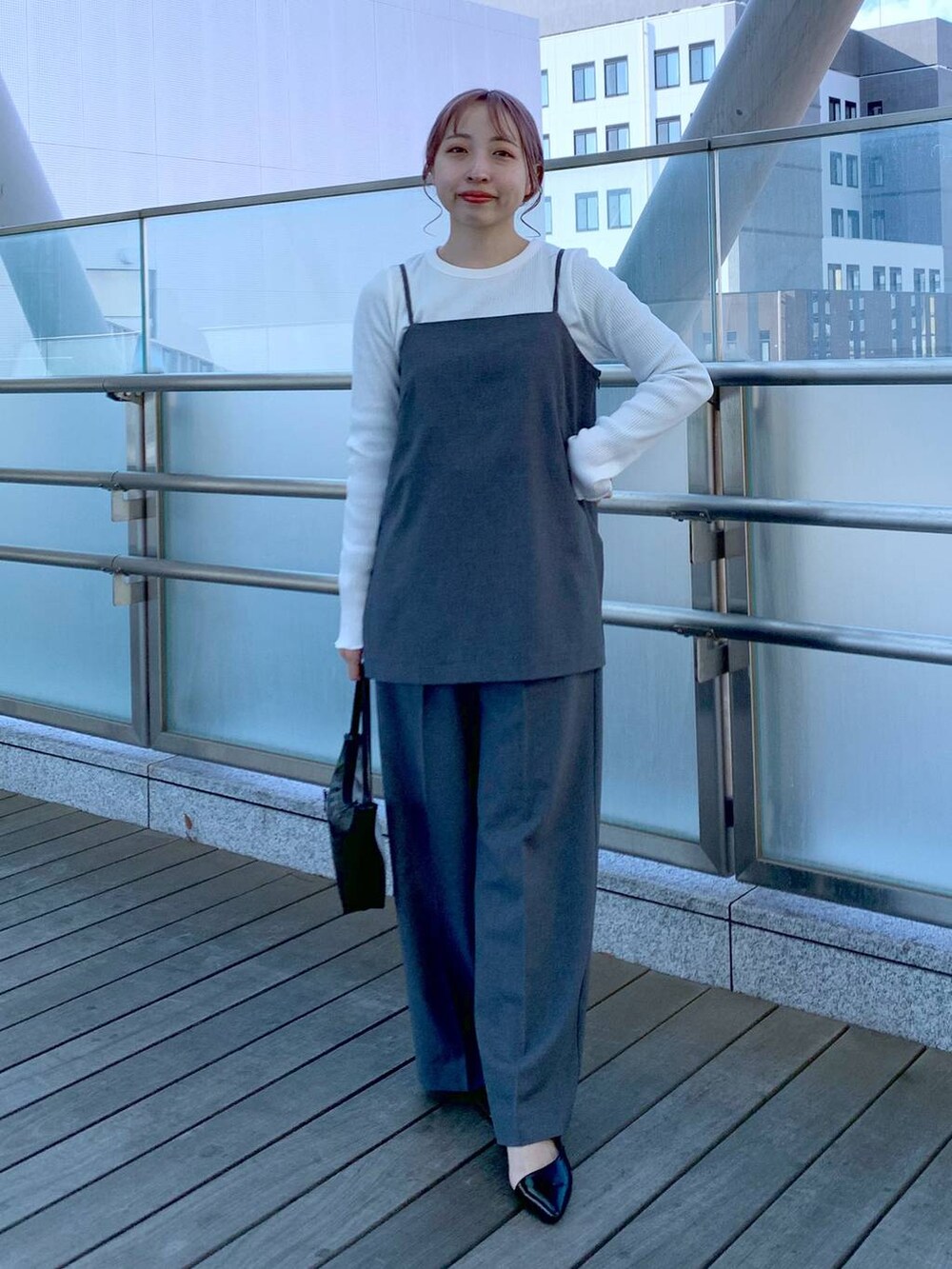 ブラック系のハンドバッグ、ホワイト系のTシャツ/カットソー、グレー系のキャミソールを着用したレディースの春コーディネートの5枚目の写真