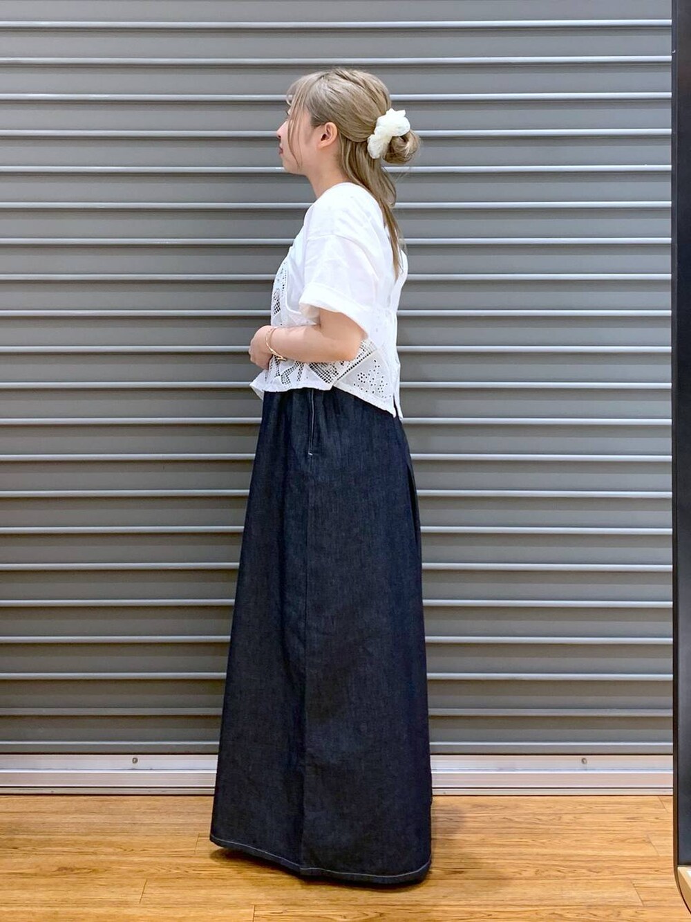 ブラック系のサンダル、ブルー系のデニムパンツ、ブラウン系のショルダーバッグを着用したレディースの夏コーディネートの3枚目の写真