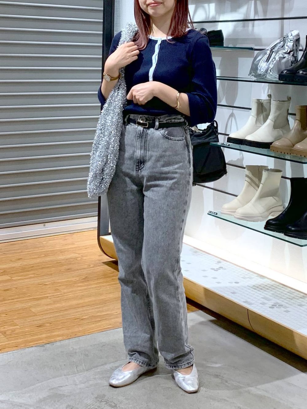 シルバー系のショルダーバッグ、シルバー系のパンプス、グレー系のデニムパンツを着用したレディースの秋コーディネートの4枚目の写真