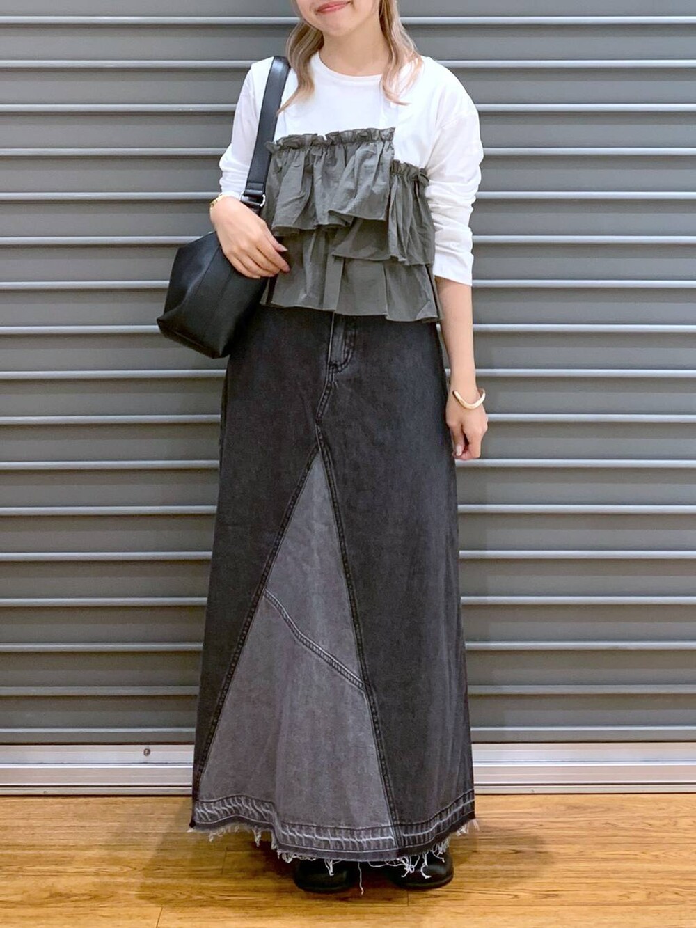 ブラック系のデニムスカート、グリーン系のTシャツ/カットソー、ブラック系のショルダーバッグを着用したレディースの秋コーディネートの4枚目の写真