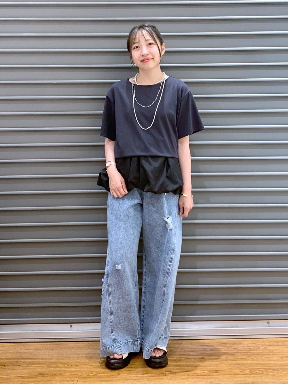 ブルー系のデニムパンツ、ホワイト系のサンダル、ブラック系のショルダーバッグを着用したレディースの秋コーディネートの7枚目の写真