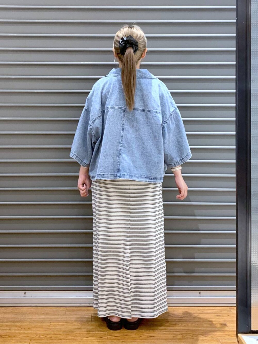 ブラック系のスカート、ホワイト系のサンダル、ホワイト系のショルダーバッグを着用したレディースの夏コーディネートの2枚目の写真