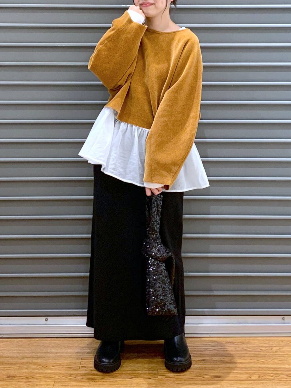 ブラック系のブーツ、ブラック系のスカート、ホワイト系のTシャツ/カットソーを着用したレディースの秋コーディネートの3枚目の写真