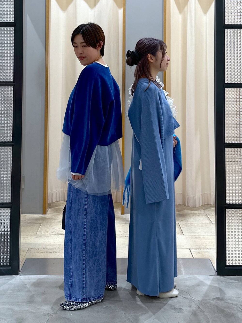 ブラック系のショルダーバッグ、シルバー系のパンプス、ホワイト系のブーツを着用したレディースの冬コーディネートの3枚目の写真