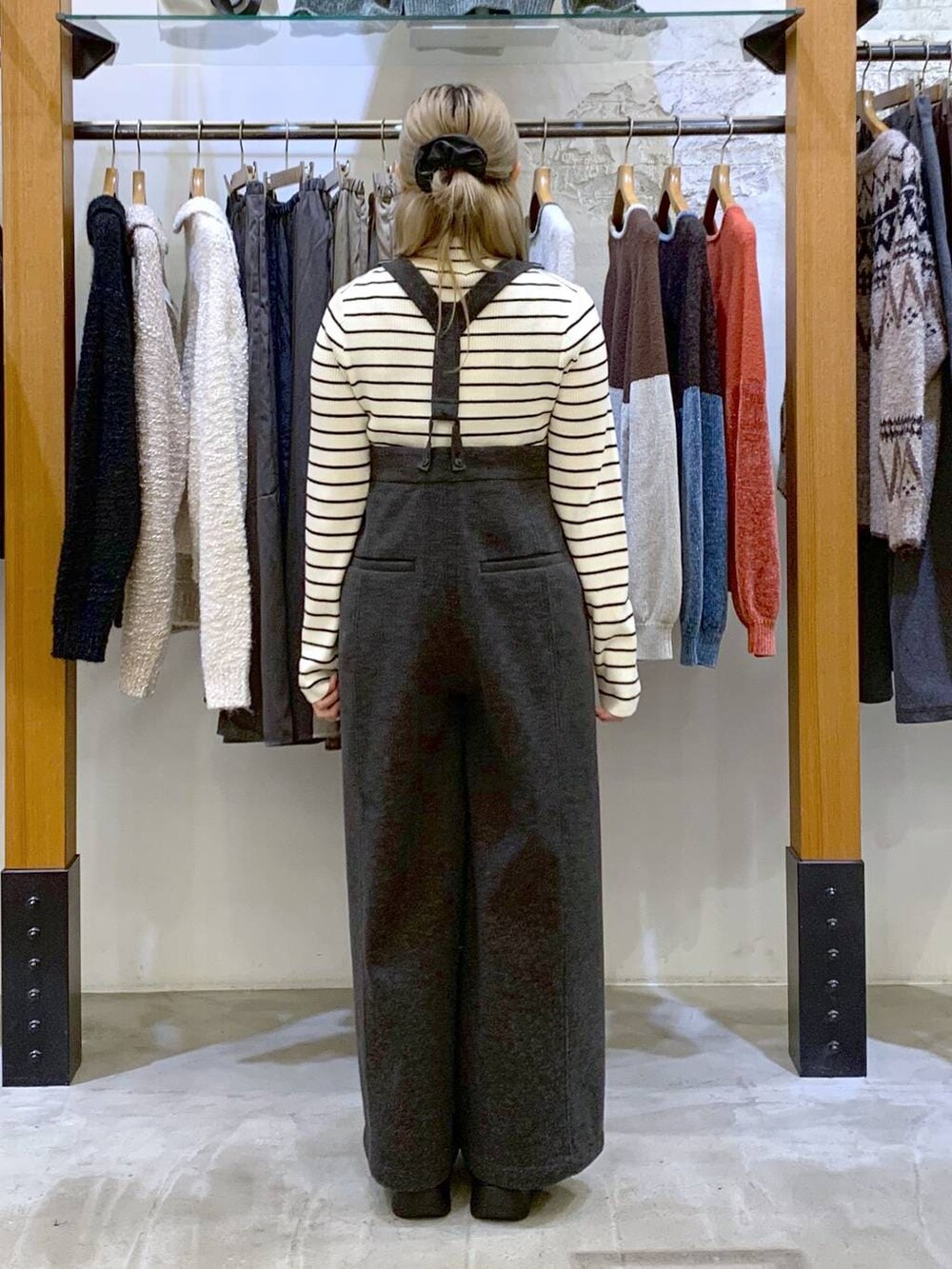 グレー系のその他パンツ、ホワイト系のニット/セーター、ブラック系のブーツを着用したレディースの秋コーディネートの4枚目の写真