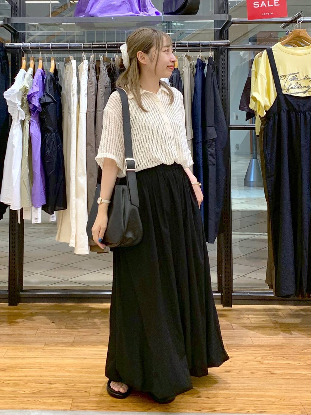 ブラック系のサンダル、ブラック系のスカート、ホワイト系のポロシャツを着用したレディースの夏コーディネートの6枚目の写真