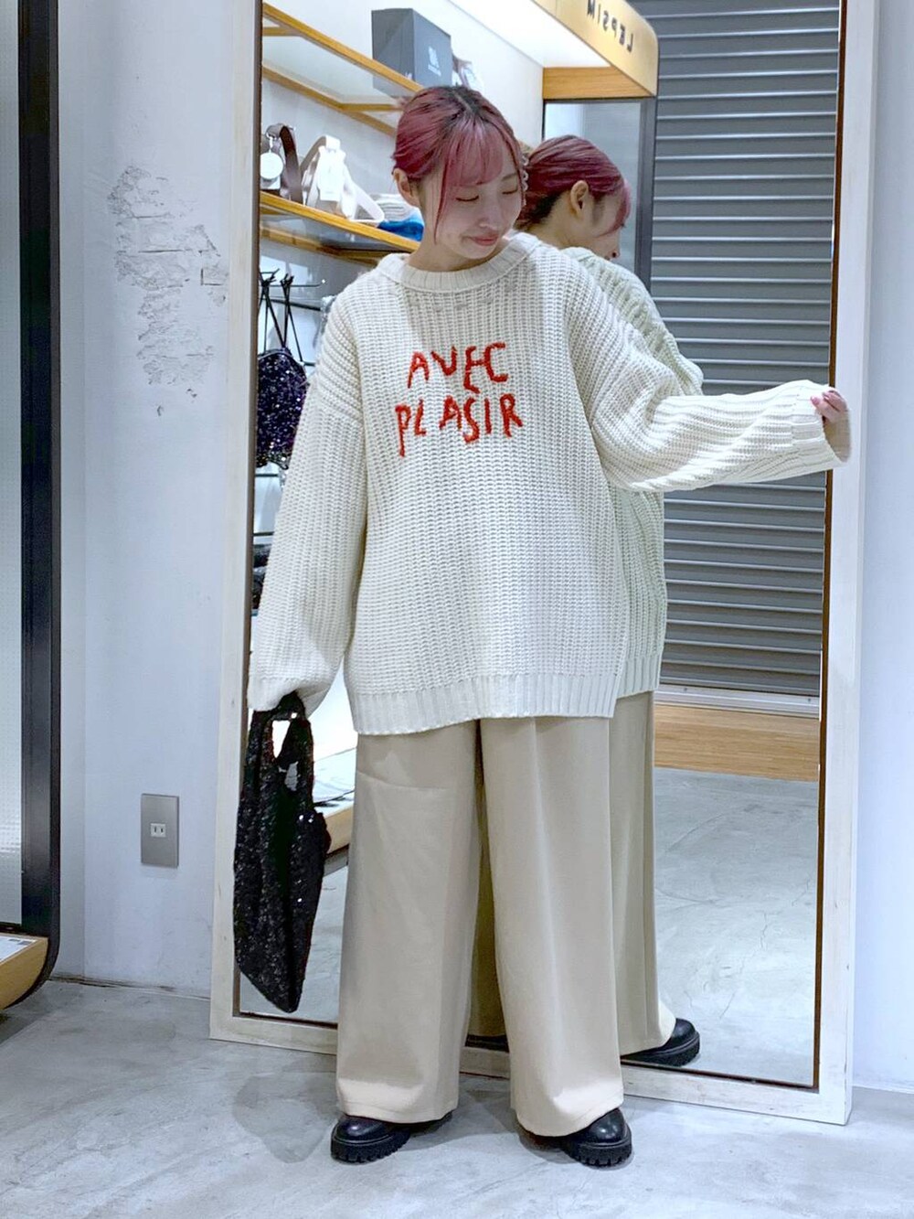 ブラック系のブーツ、ホワイト系のニット/セーター、ブラック系のハンドバッグを着用したレディースの秋コーディネートの5枚目の写真