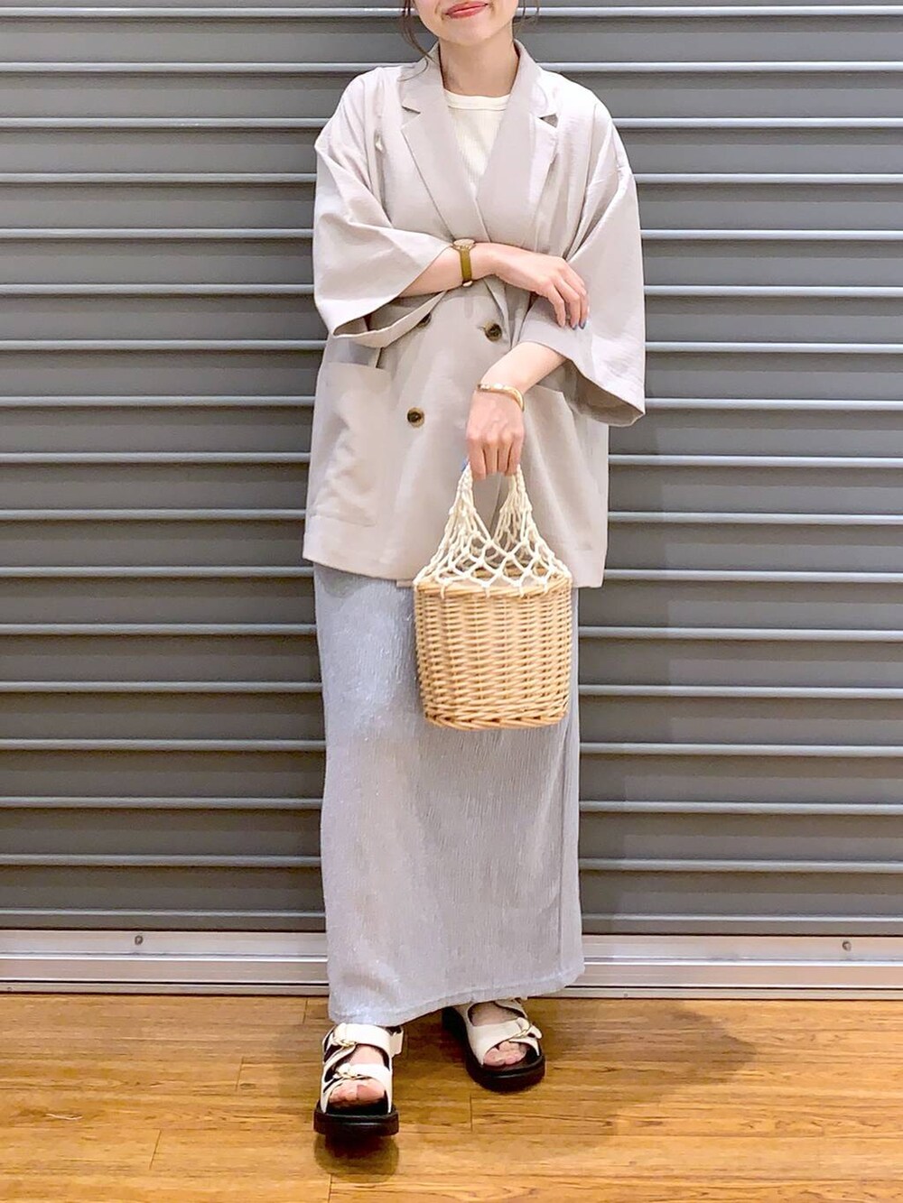 ベージュ系のテーラードジャケット、ホワイト系のサンダル、グレー系のスカートを着用したレディースの夏コーディネートの3枚目の写真