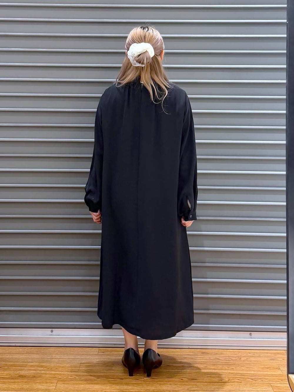 ブラック系のテーラードジャケット、ブラック系のワンピース、ブラック系のショルダーバッグを着用したレディースの冬コーディネートの3枚目の写真