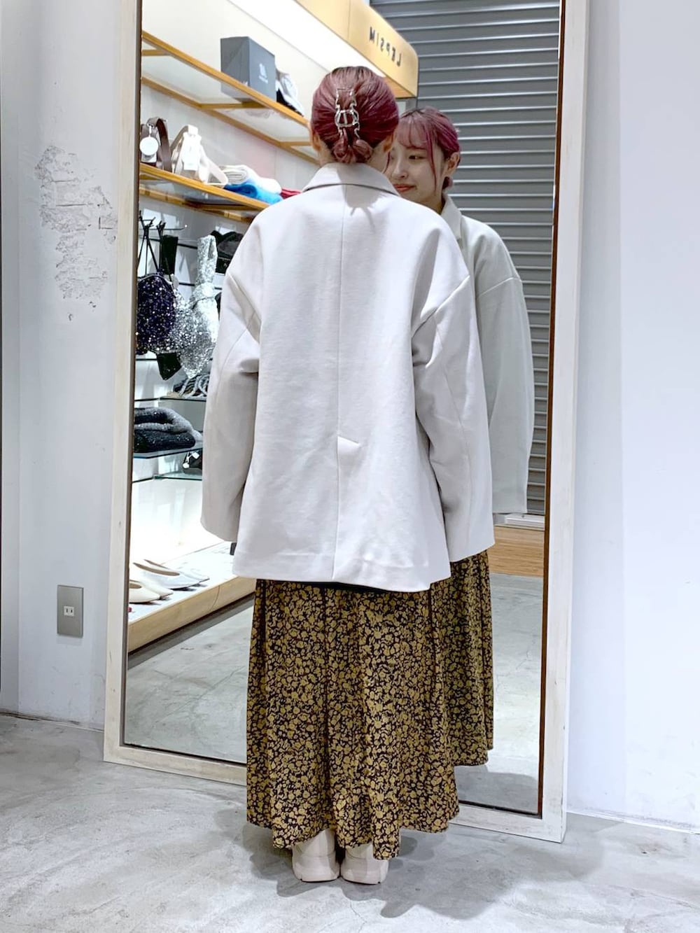 ホワイト系のその他アウター、ホワイト系のブーツ、ブラック系のショルダーバッグを着用したレディースの冬コーディネートの2枚目の写真