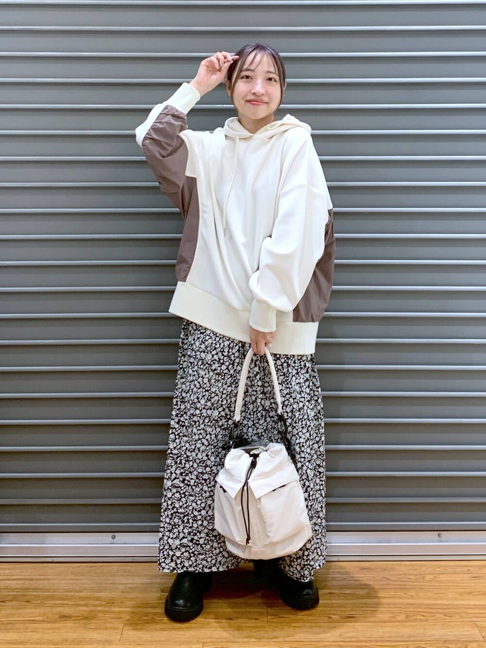 ホワイト系のショルダーバッグ、ブラック系のブーツ、ホワイト系のパーカーを着用したレディースの冬コーディネートの8枚目の写真