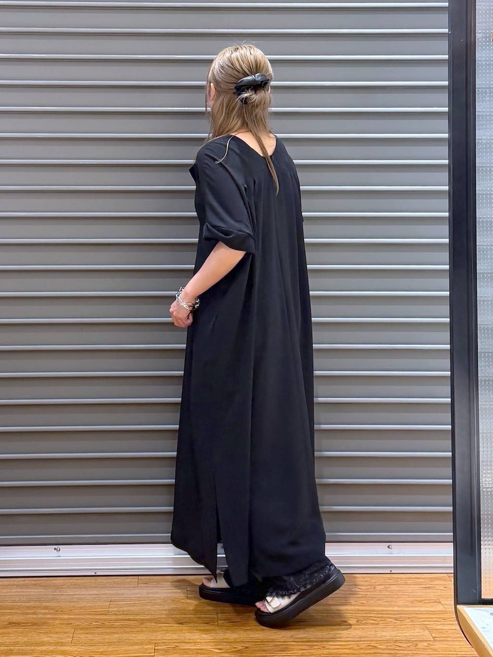 ブラック系のショルダーバッグ、ホワイト系のサンダル、ブラック系のワンピースを着用したレディースの夏コーディネートの3枚目の写真