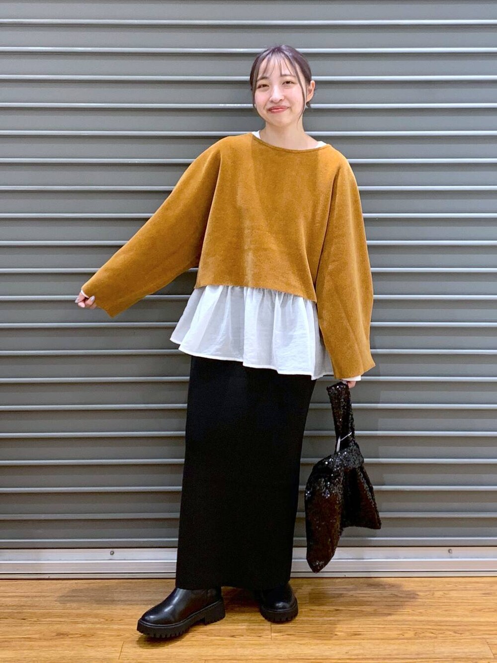 ブラック系のブーツ、ブラック系のスカート、ホワイト系のTシャツ/カットソーを着用したレディースの秋コーディネートの4枚目の写真