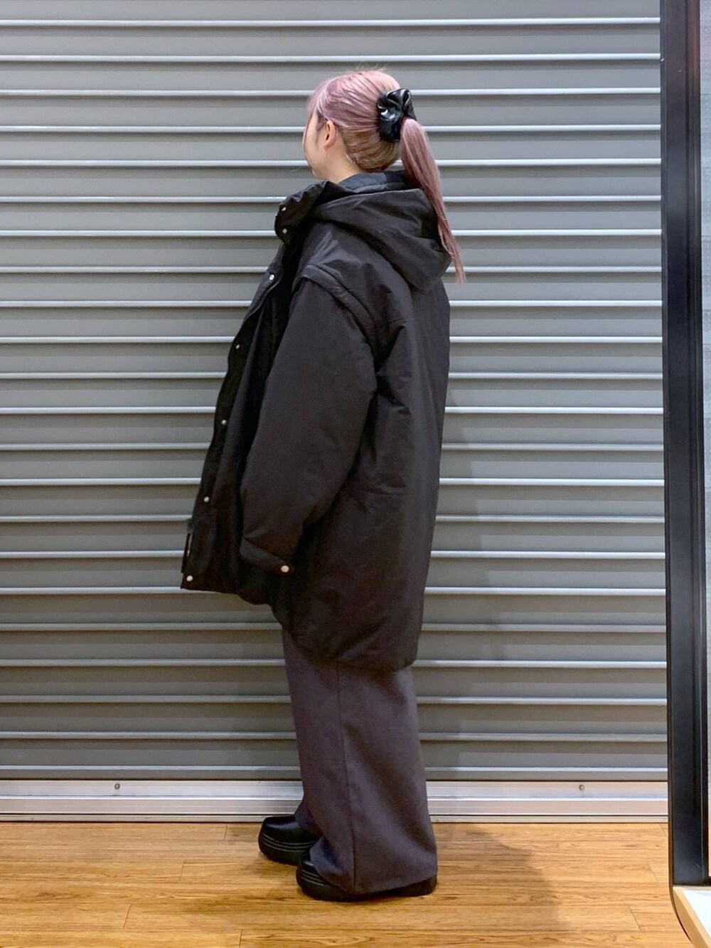 ブラック系のその他アウター、ブラック系のブーツ、ブラック系のショルダーバッグを着用したレディースの冬コーディネートの4枚目の写真