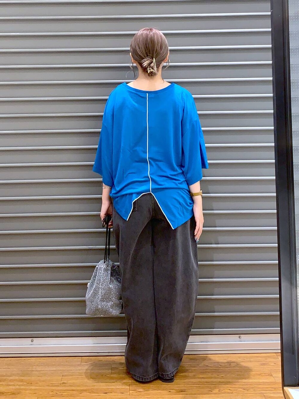 ブルー系のTシャツ/カットソー、グレー系のショルダーバッグ、ブラック系のデニムパンツを着用したレディースの夏コーディネートの2枚目の写真