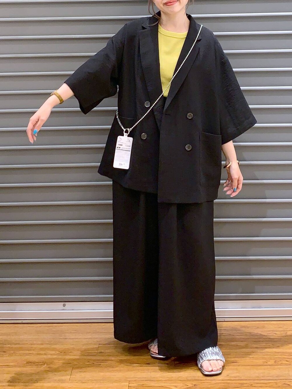 ブラック系のその他パンツ、ブラック系のテーラードジャケット、イエロー系のタンクトップを着用したレディースの夏コーディネートの3枚目の写真