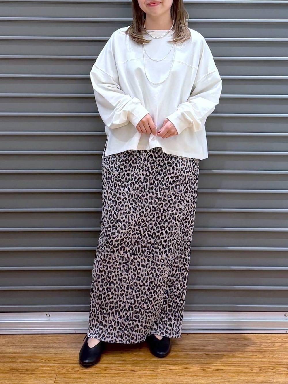 ブラック系のショルダーバッグ、ホワイト系のTシャツ/カットソー、ブラック系のパンプスを着用したレディースの春コーディネートの5枚目の写真