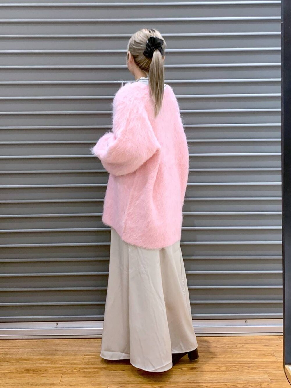 ブラック系のショルダーバッグ、ホワイト系のニット/セーター、ブラック系のブーツを着用したレディースの冬コーディネートの5枚目の写真