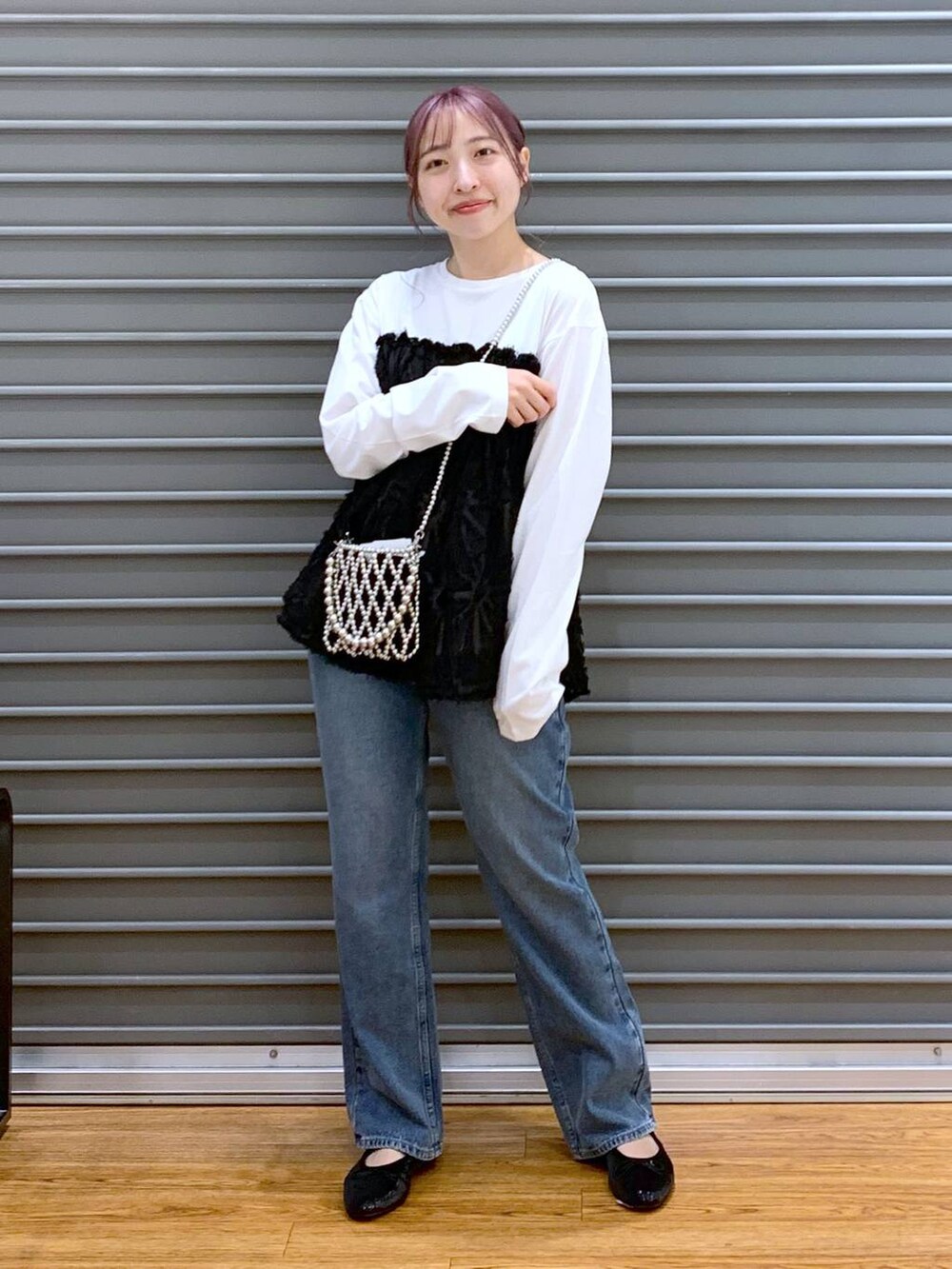 シルバー系のショルダーバッグ、ブルー系のデニムパンツ、ブラック系のバレエシューズを着用したレディースの秋コーディネートの6枚目の写真