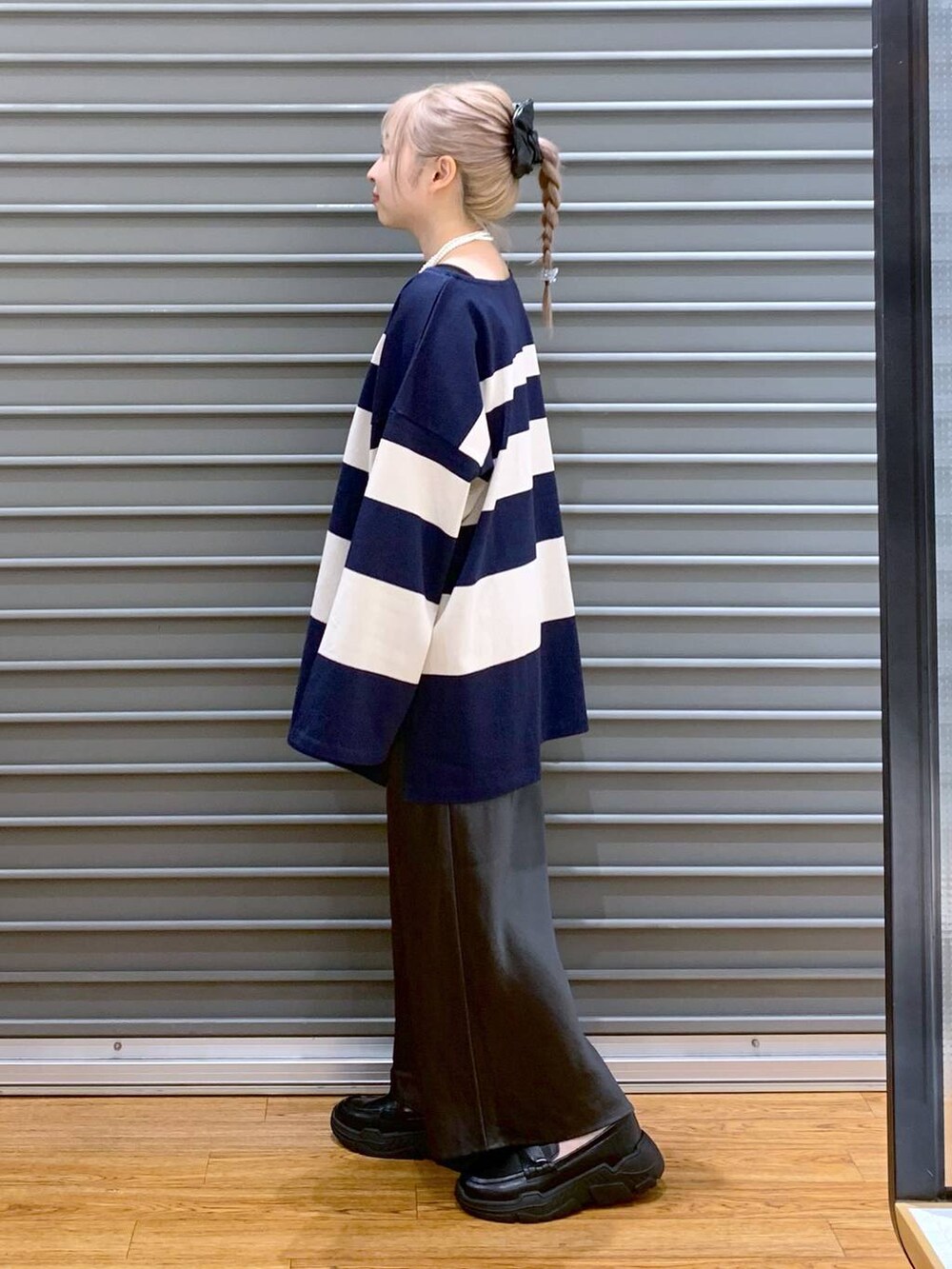 グレー系のスカート、グレー系のショルダーバッグ、ブラック系のスニーカーを着用したレディースの秋コーディネートの3枚目の写真