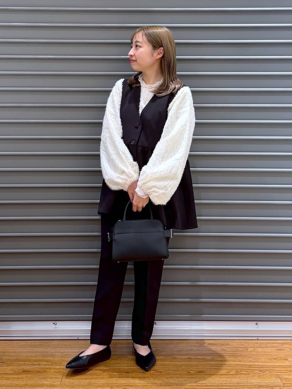 ブラック系のその他パンツ、ブラック系のその他アウター、ベージュ系のシャツ/ブラウスを着用したレディースの冬コーディネートの6枚目の写真